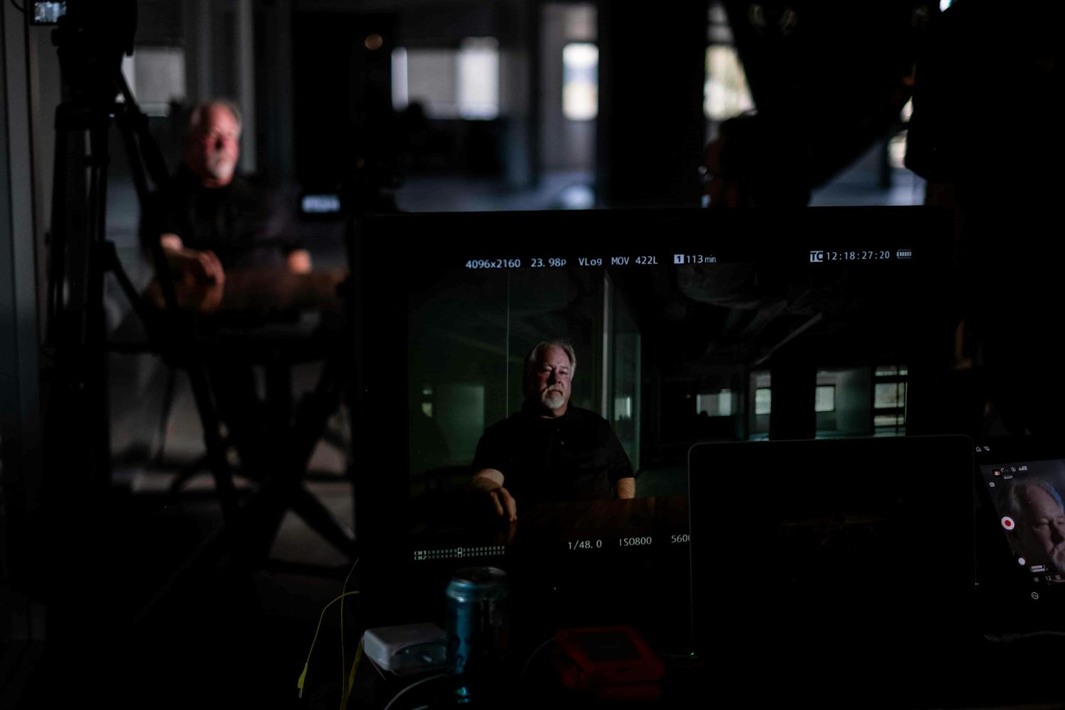 Man being interviewed seen through camera screen