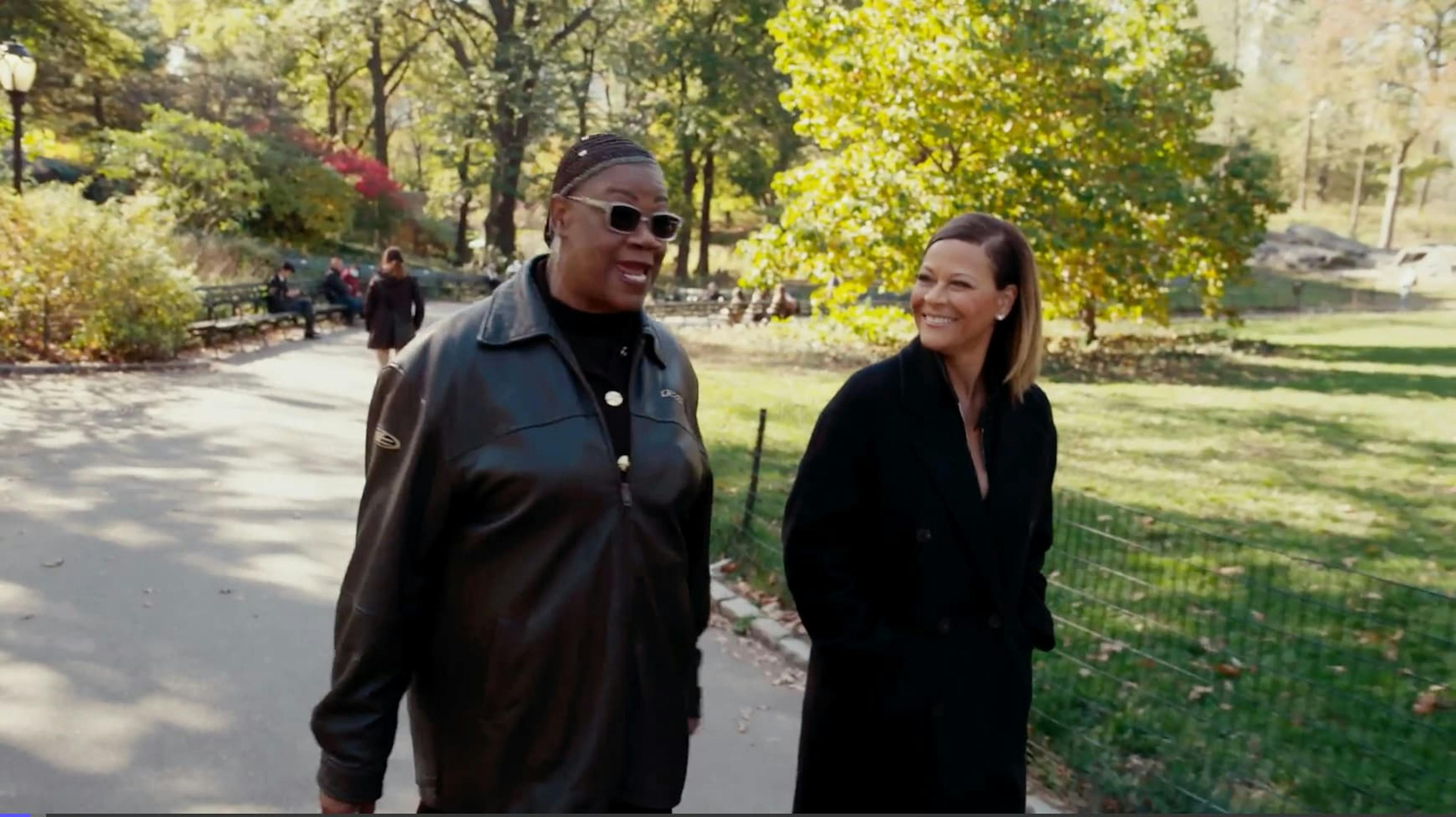 Two women walking through park