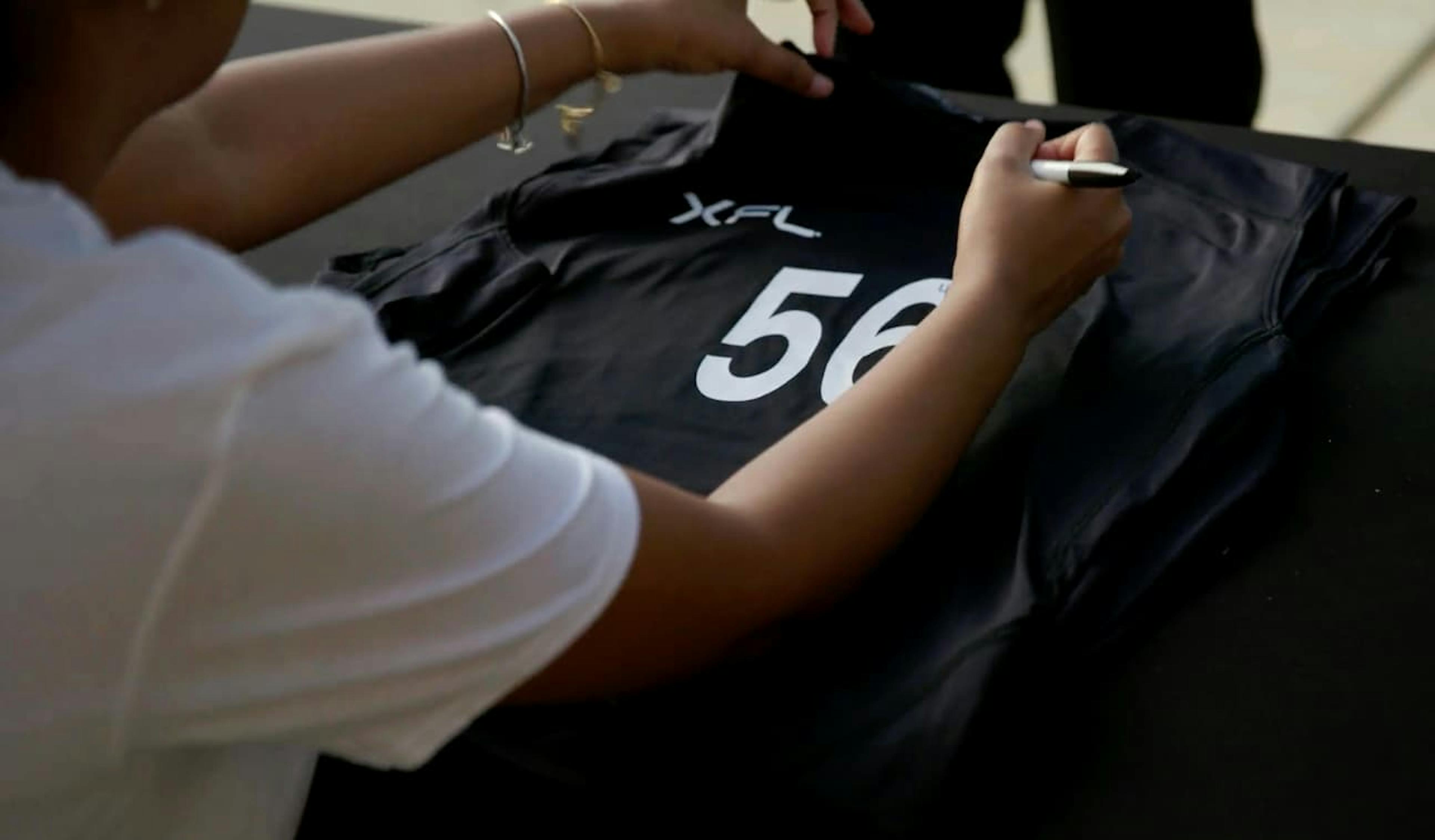 Someone signing sports jersey
