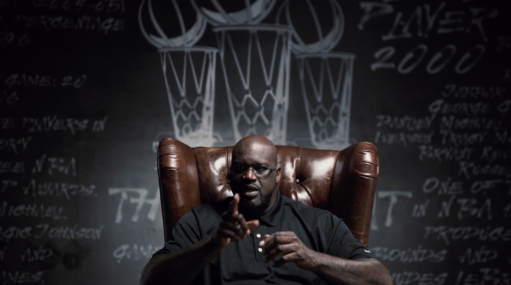 Man sat in leather chair pointing at camera