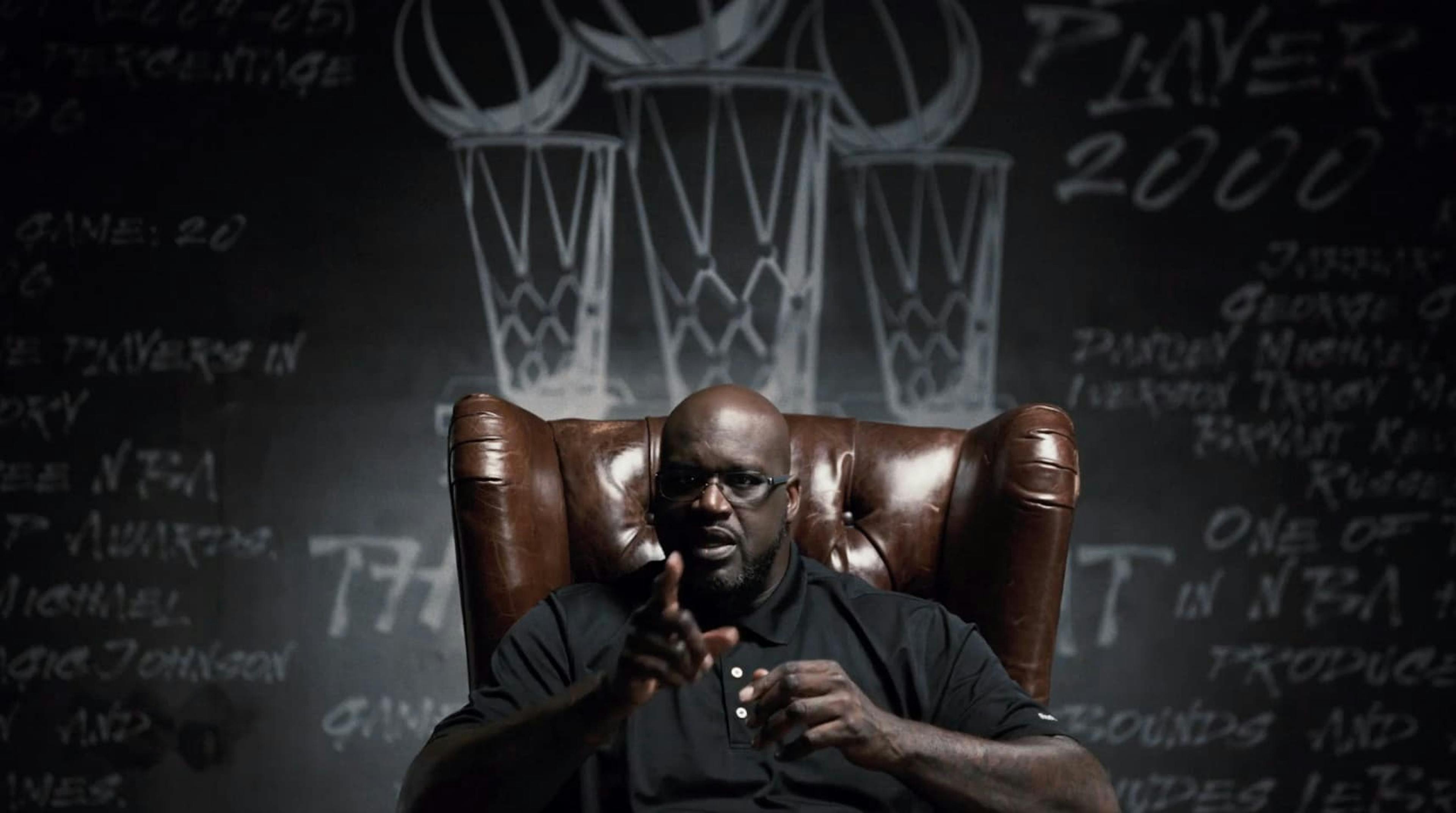 Man sat in leather chair pointing at camera
