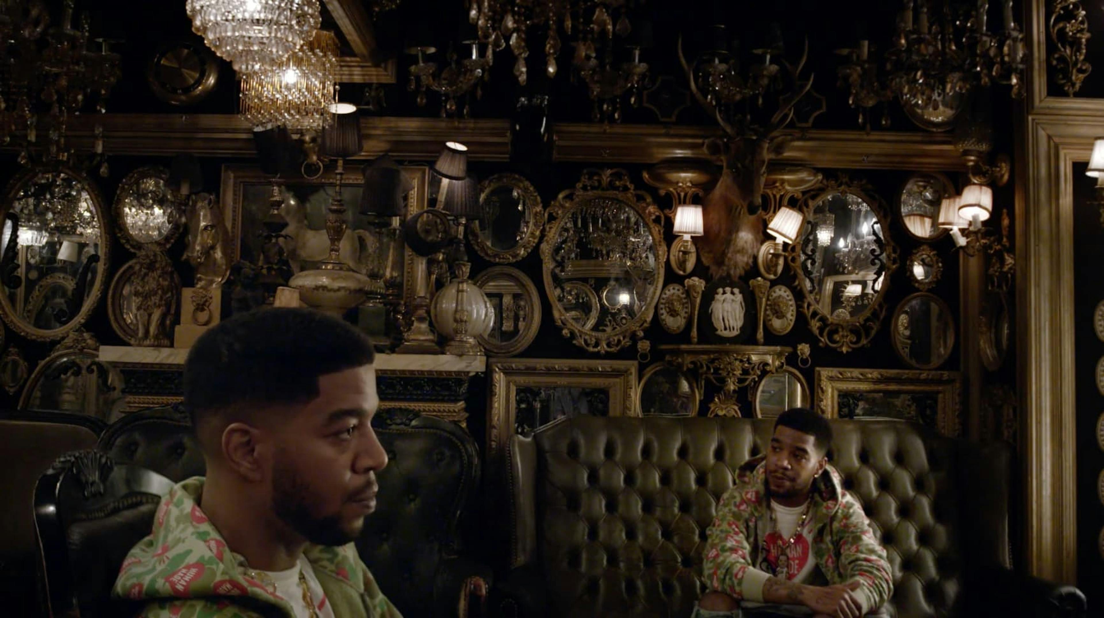 Two men sat in room with lots of mirrors on the walls