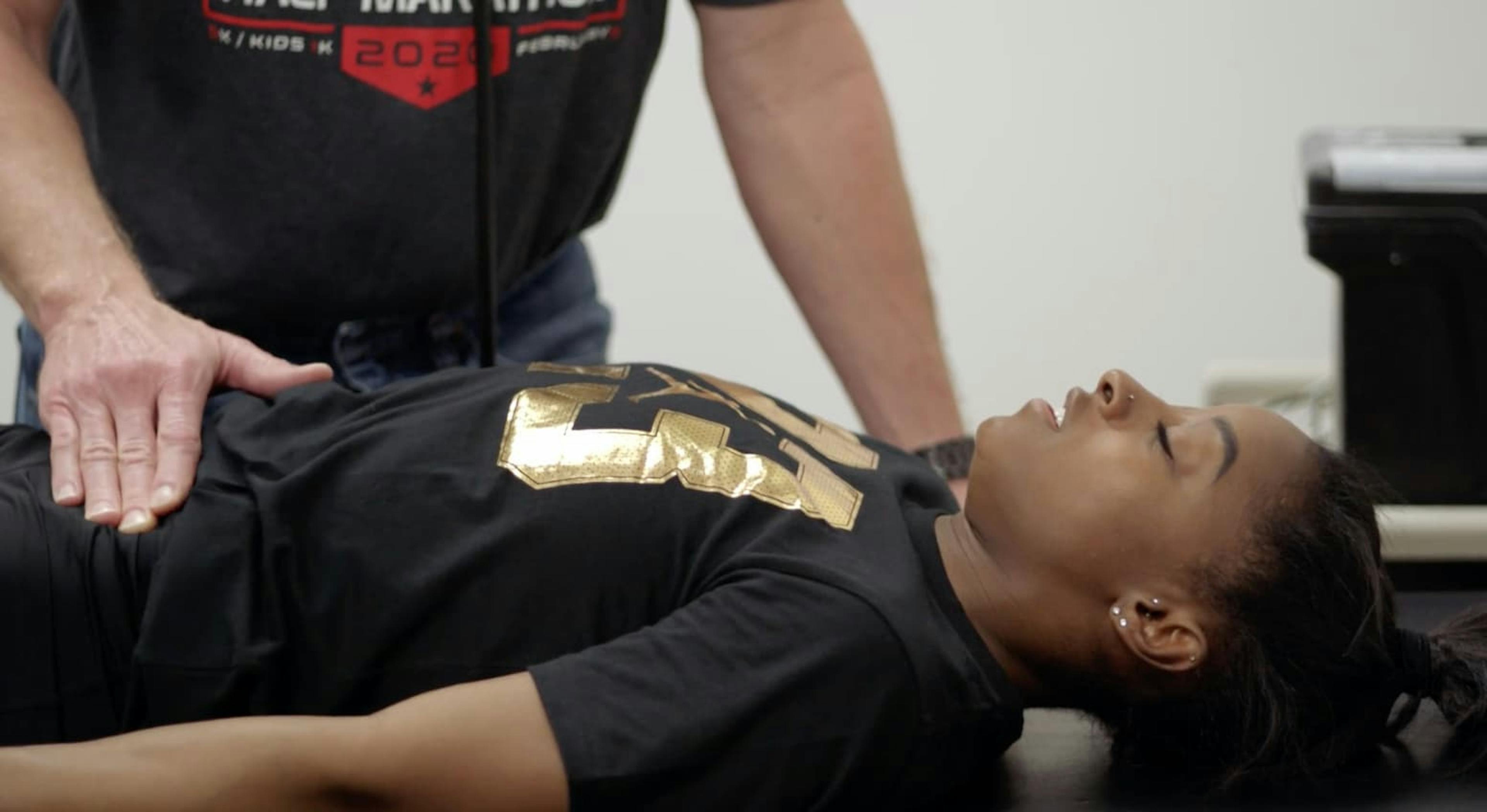 Gymnast lying on table having medical examination