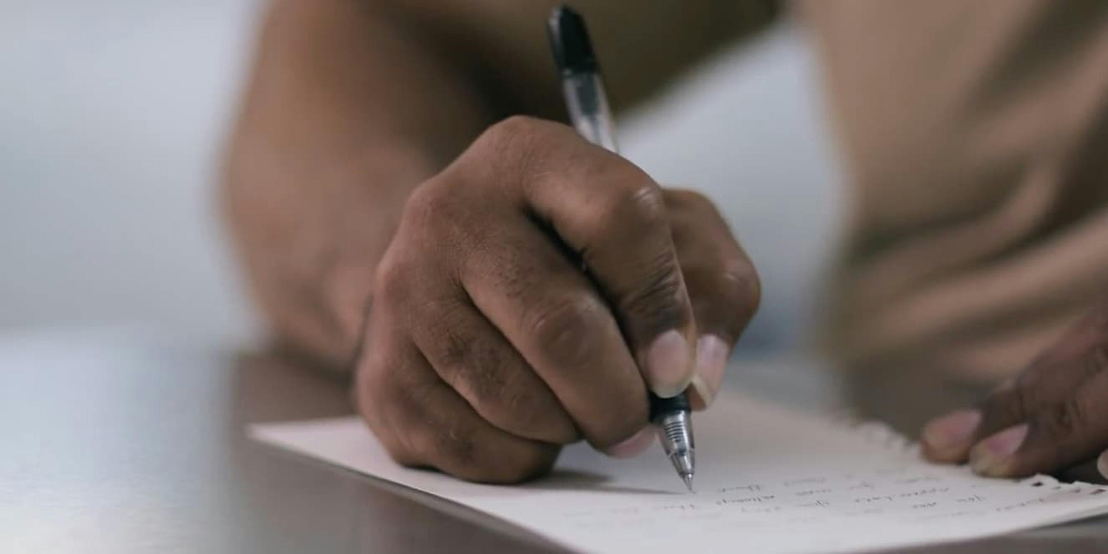 Person writing something on piece of paper