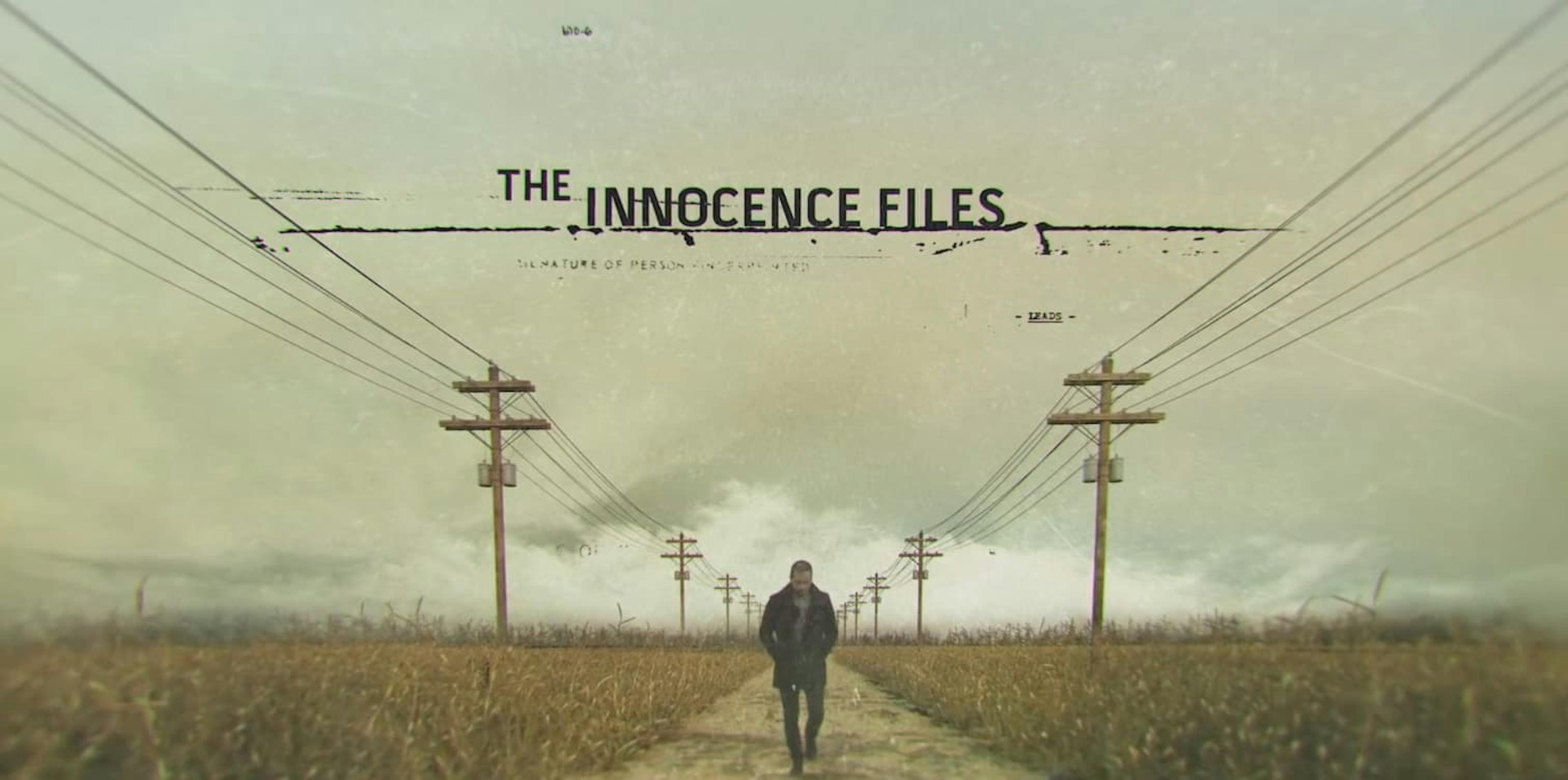 Man walking down road with electricity towers either side of him