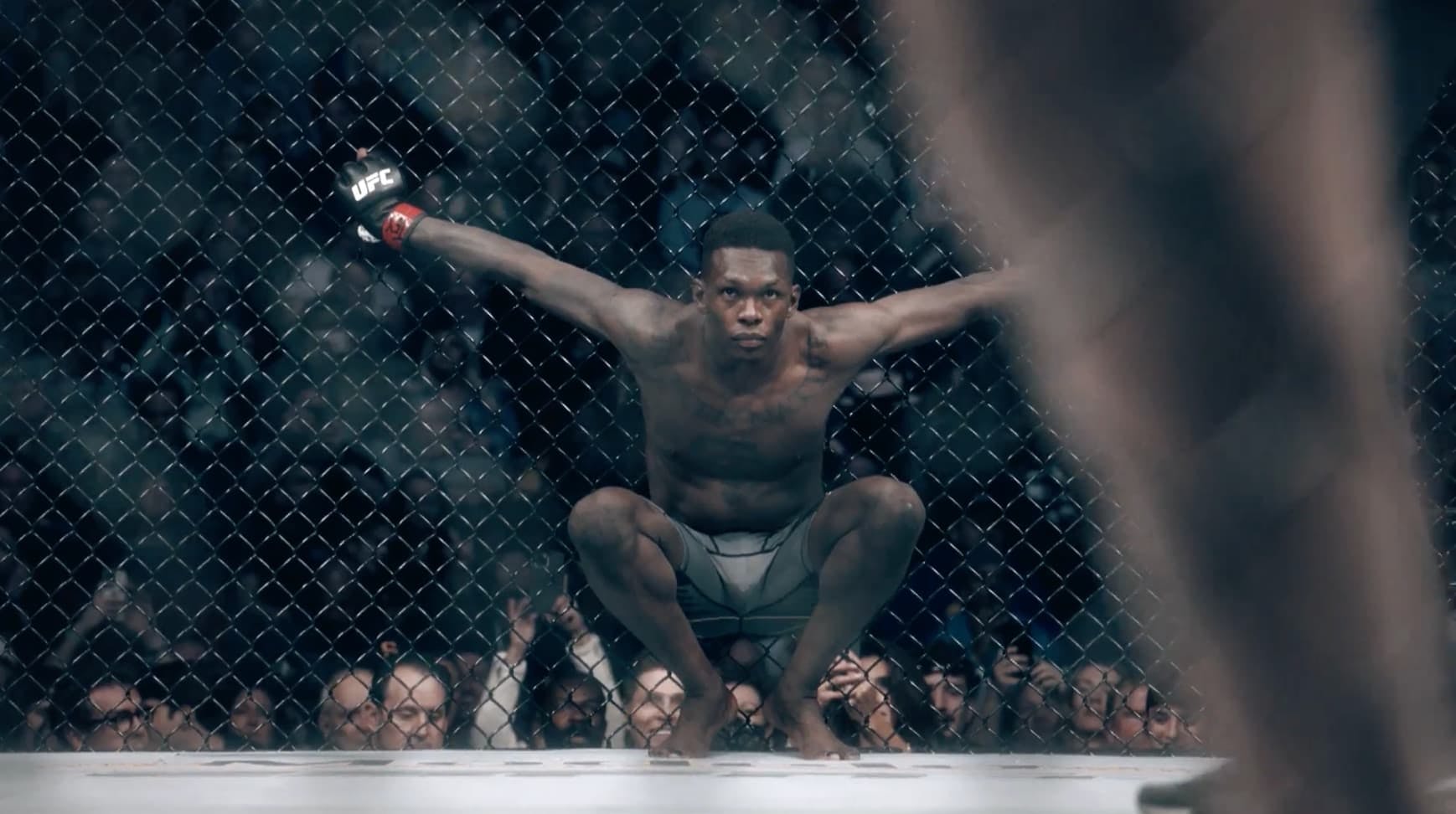 Boxer crouched down holding the railings in boxing ring 