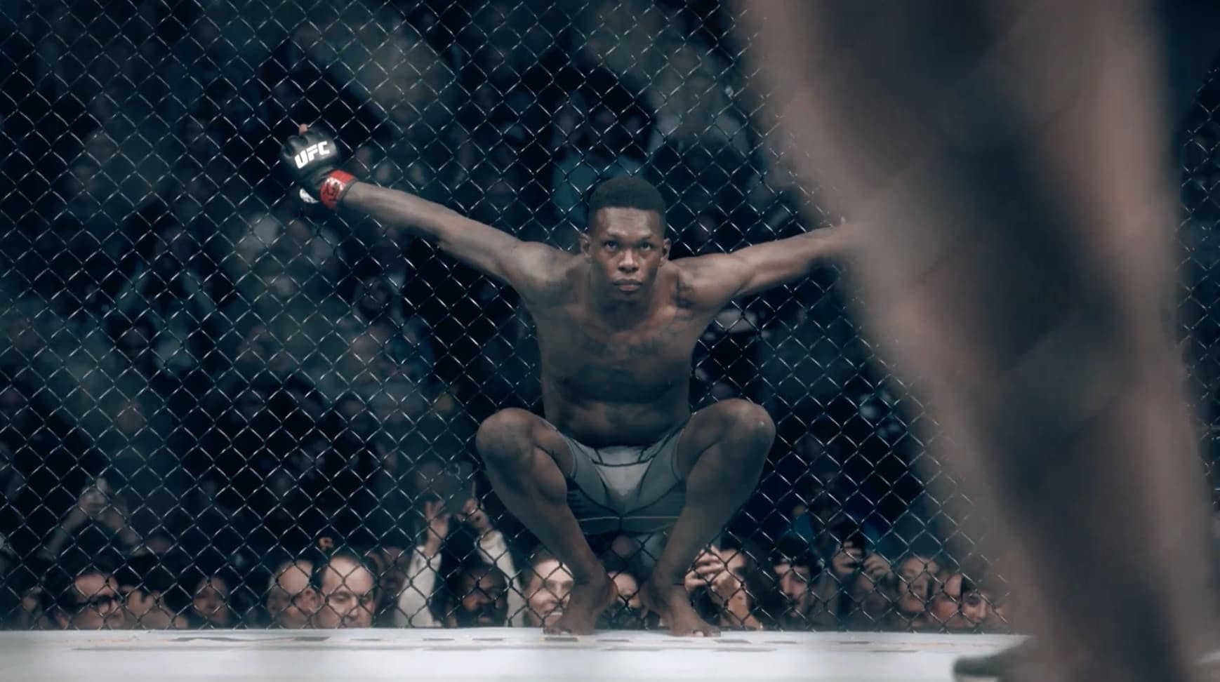 Boxer crouched down holding the railings in boxing ring