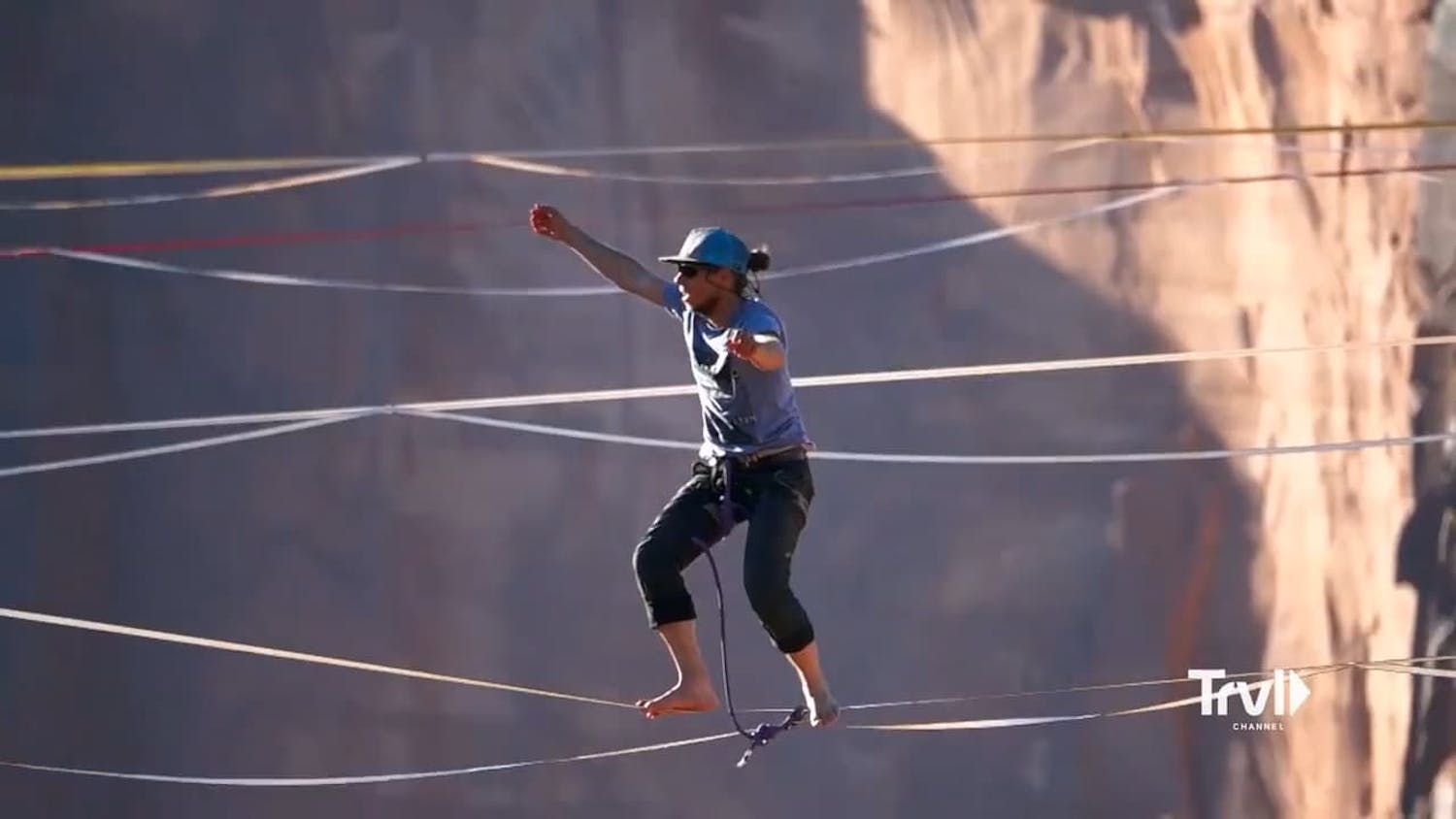 Woman walking on ropes over canyon