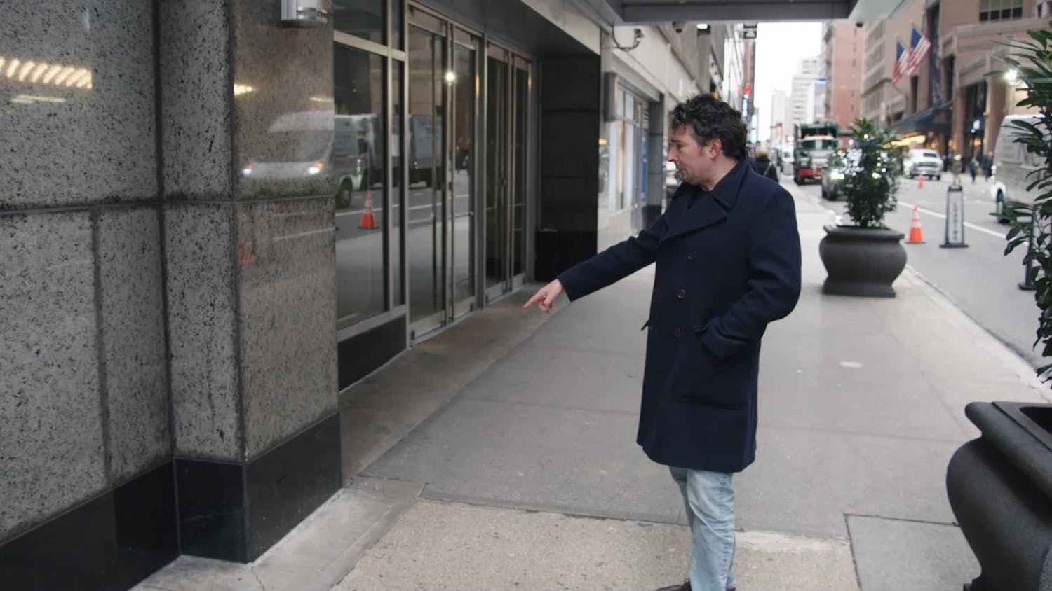 Man pointing outside building