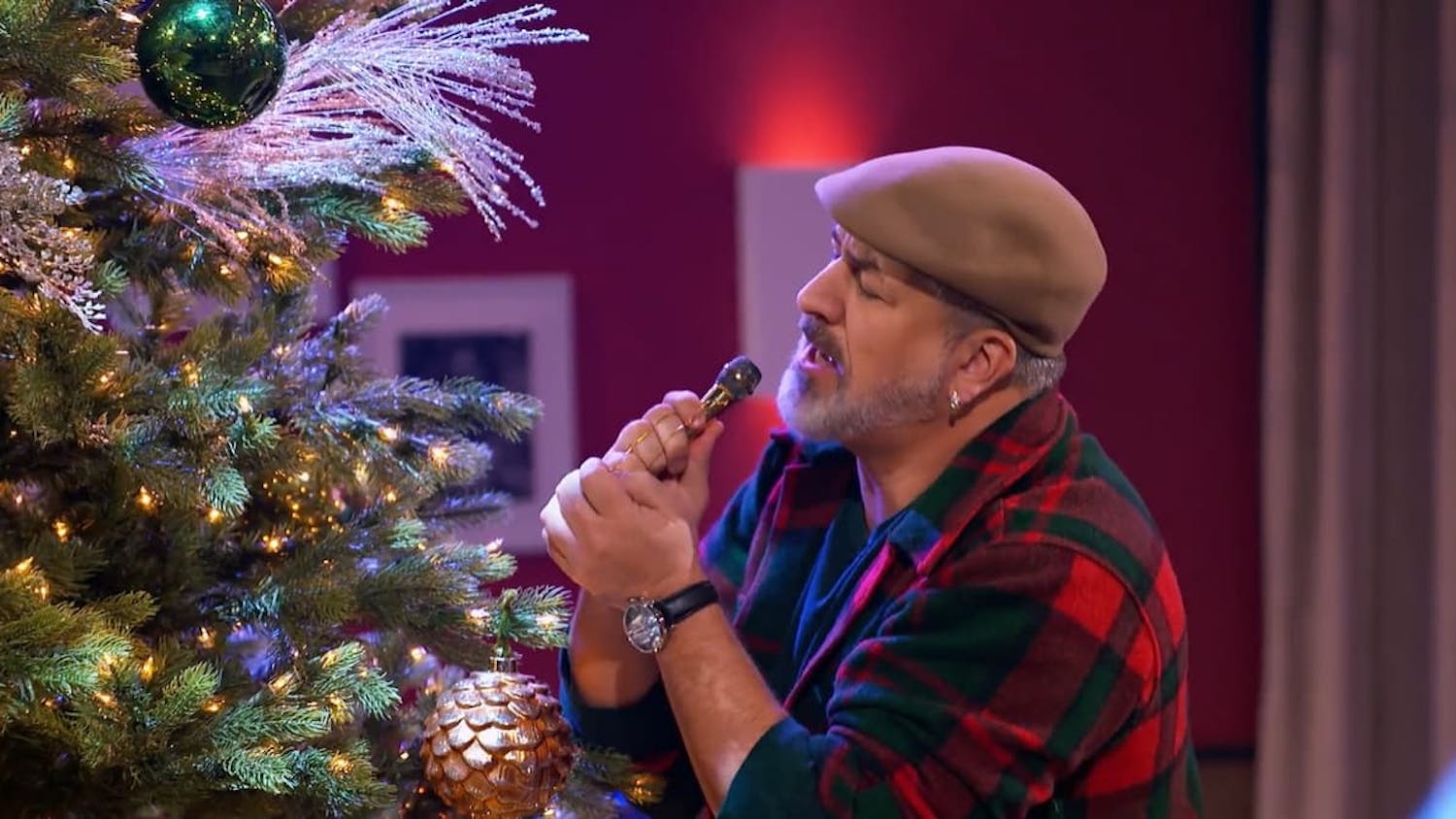 Man singing next to Christmas Tree