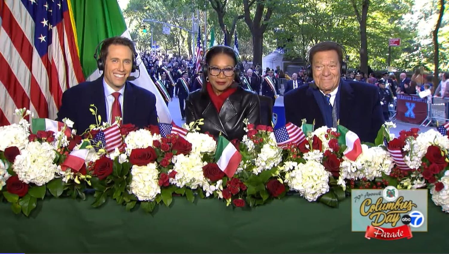 Three people sat at table with flowers in front of them