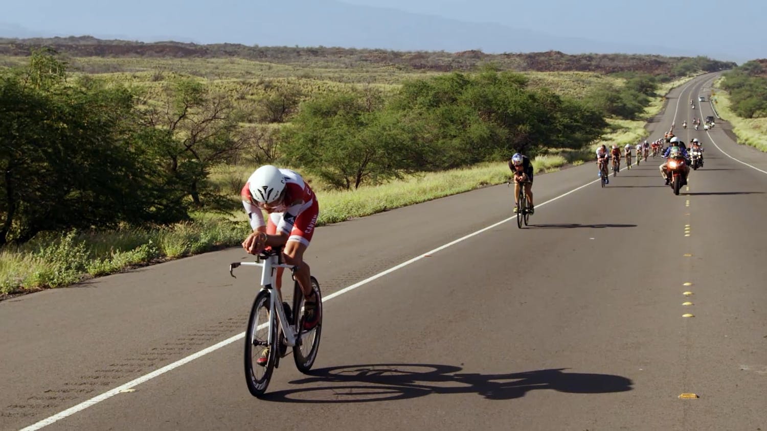 Cyclists riding along road