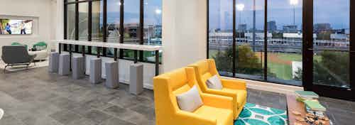 Interior view of skybox suite with seating areas overlooking Dr Pepper Ballpark at AMLI Frisco Crossing apartment building