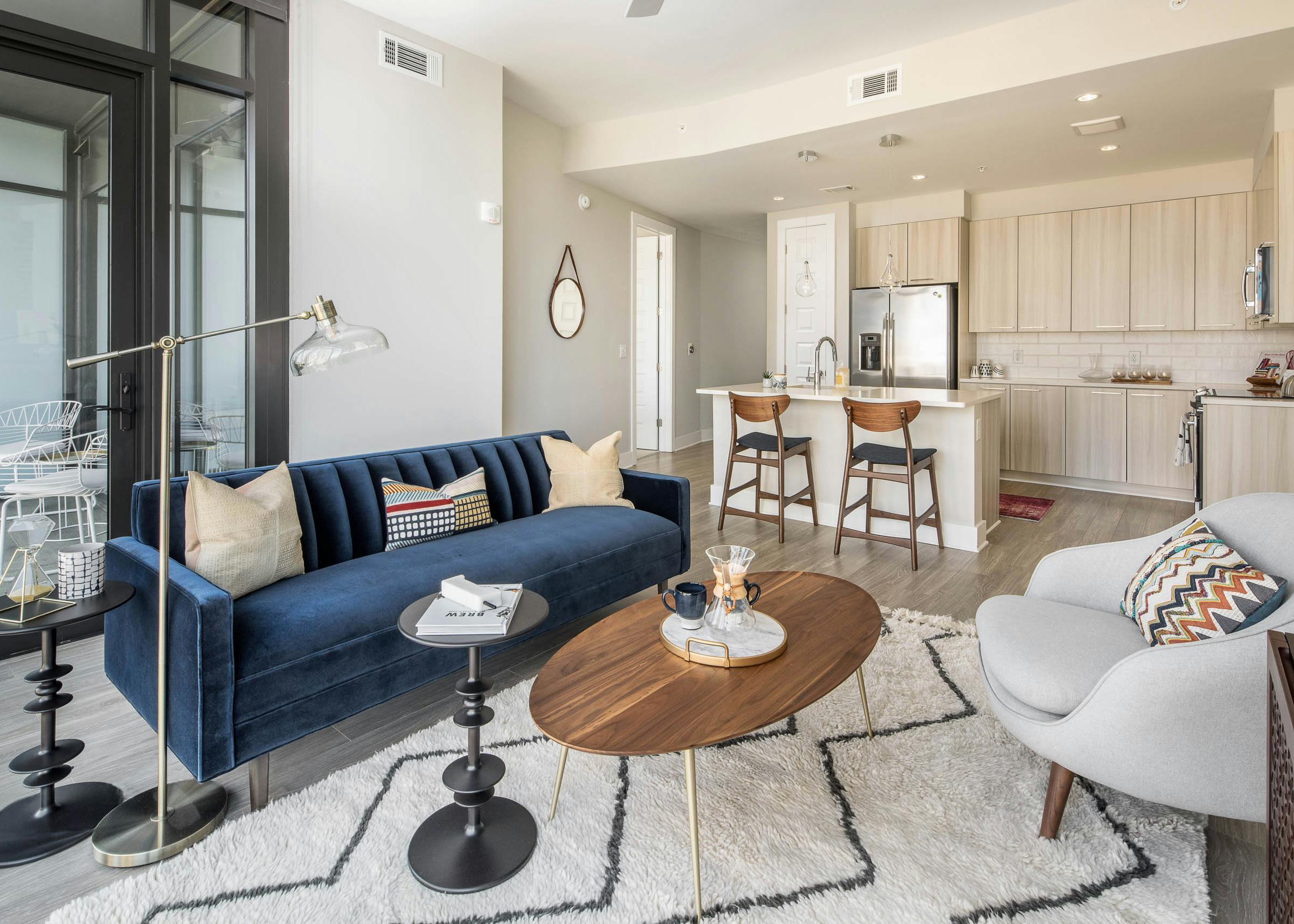 Living room at AMLI Arts Center leading from the kitchen with floor to ceiling windows overlooking the city