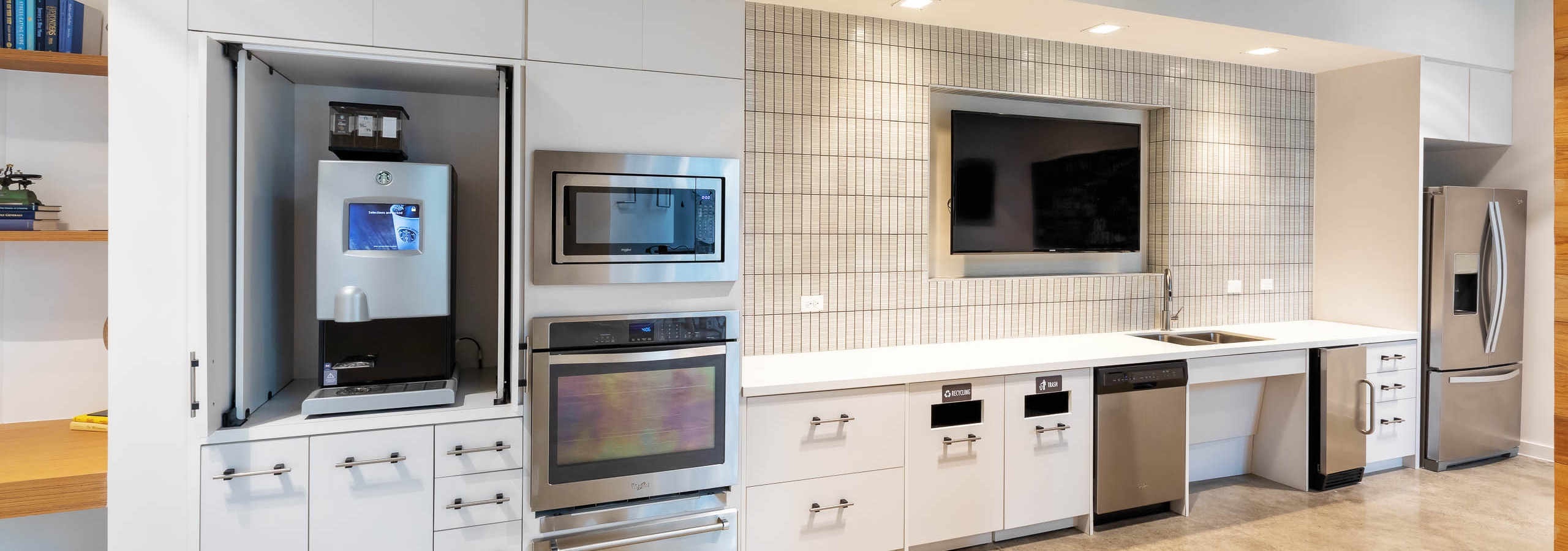 Interior of clubroom java bar and serving kitchen with stainless steel appliances at AMLI Frisco Crossing apartment building