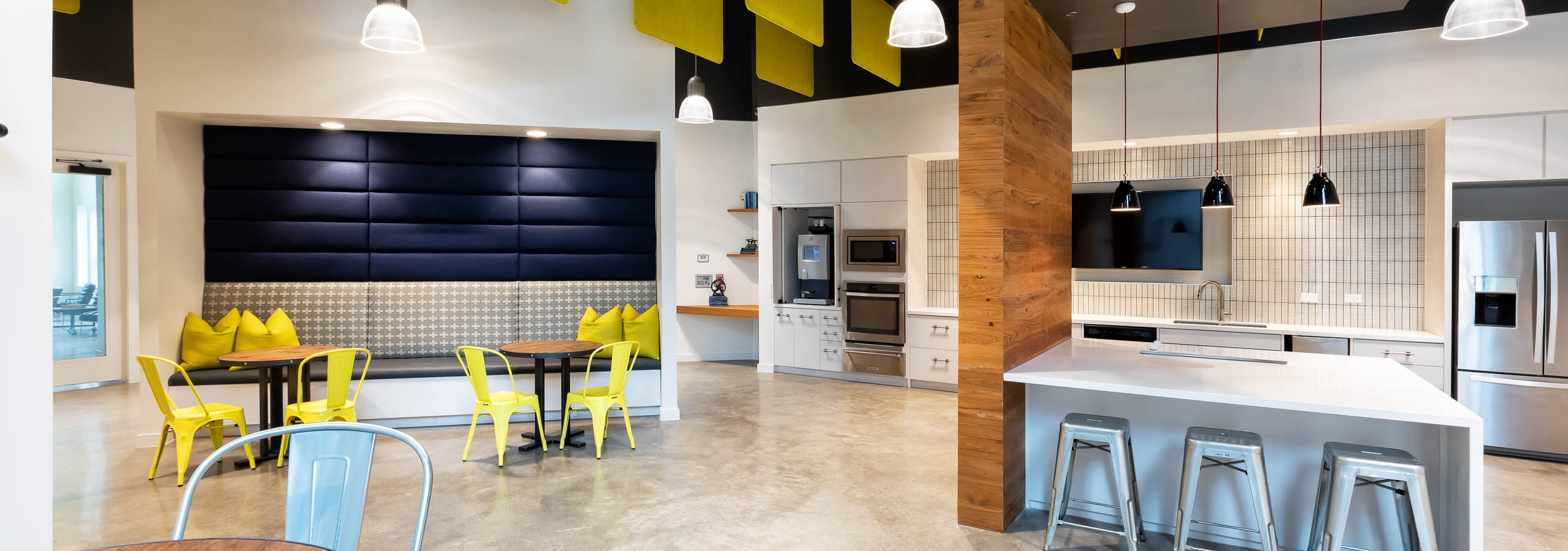 Interior of clubroom at AMLI Frisco Crossing apartment building with coffee station and serving kitchen with booth and tables