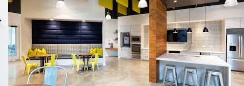 Interior of clubroom at AMLI Frisco Crossing apartment building with coffee station and serving kitchen with booth and tables