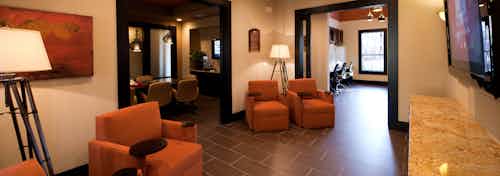 Interior view of resident lounge at AMLI at Escena apartment building with large orange chairs and big screen TV