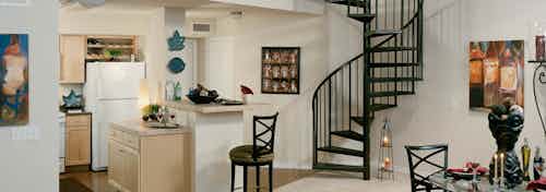 Interior view of townhome kitchen and dining room at AMLI Memorial Heights apartments with stairs leading to upstairs loft