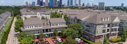 Daytime aerial of AMLI Memorial Heights apartment buildings with clubhouse and parking lot in foreground and city at back