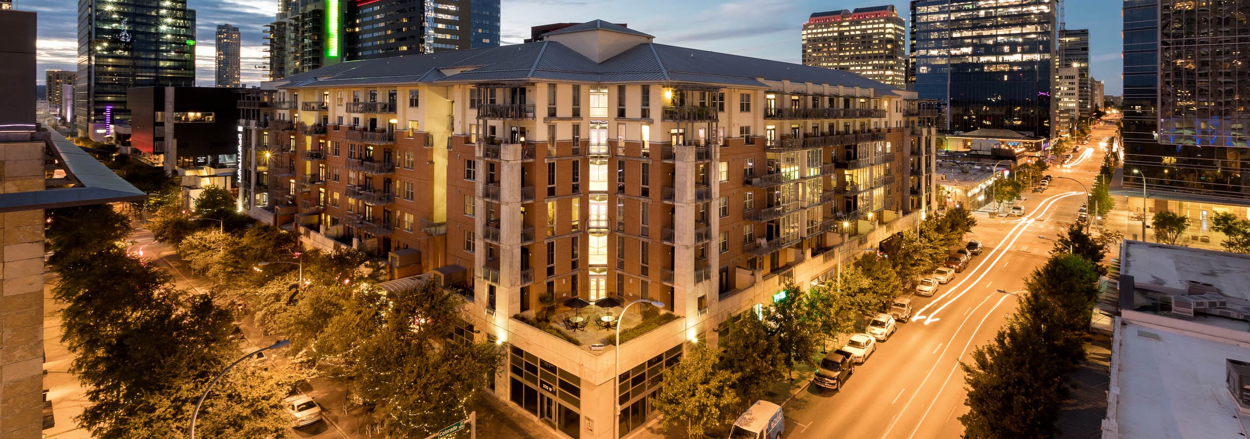 Aerial night view of corner of AMLI Downtown apartment building with surrounding buildings