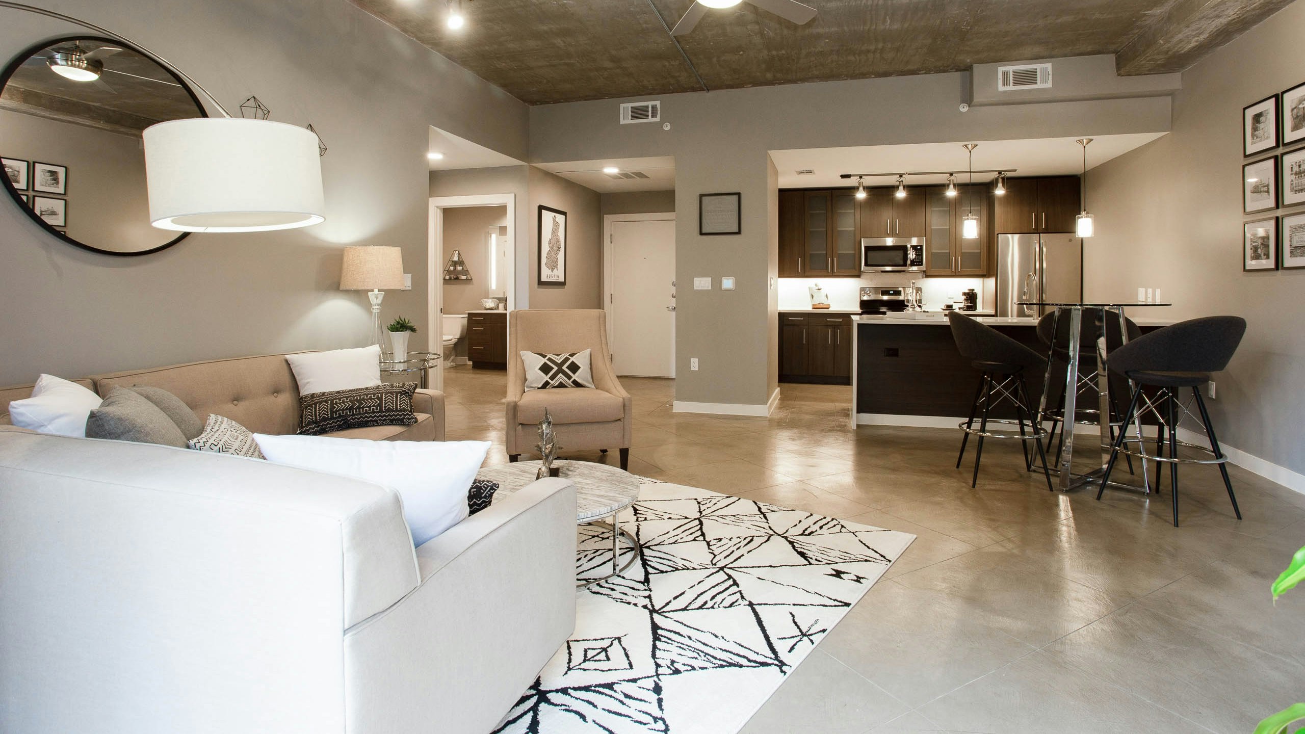 AMLI Downtown furnished apartment living room with view into dining area and kitchen with brown cabinets