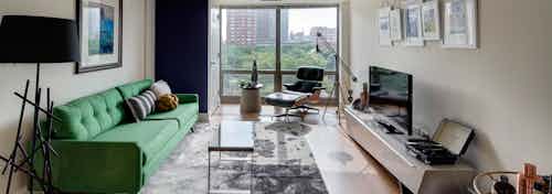 Interior view of an AMLI 900 living room which has cream colored walls paired with light wood flooring and vintage decor