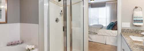Interior view of bathroom at AMLI Memorial Heights with stand-up shower and oval garden tub and view into adjacent bedroom