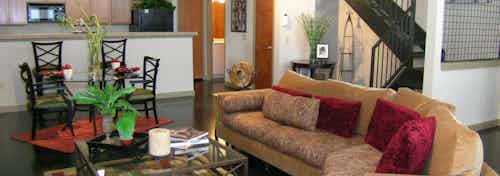 Townhome living room with couch and dining room and kitchen at AMLI Memorial Heights with stairs leading to upstairs