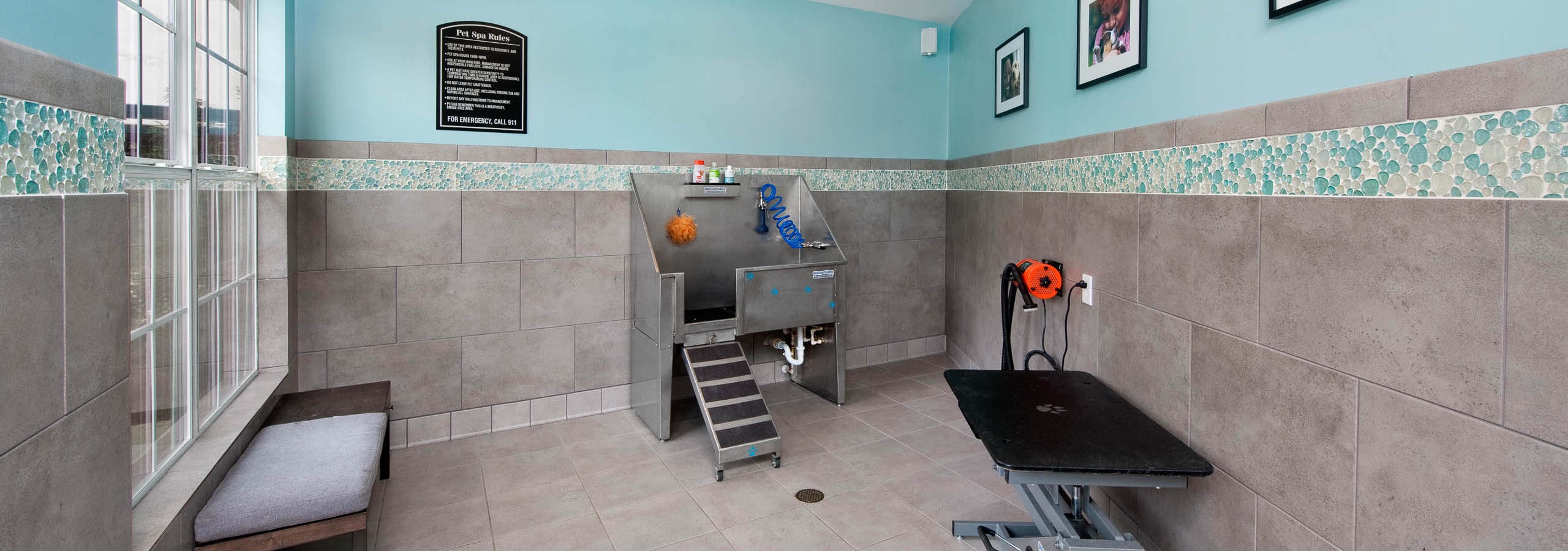 AMLI Piedmont Heights paw wash room with stainless steel dog tub and grooming area to dry off with grey tiled floor and walls
