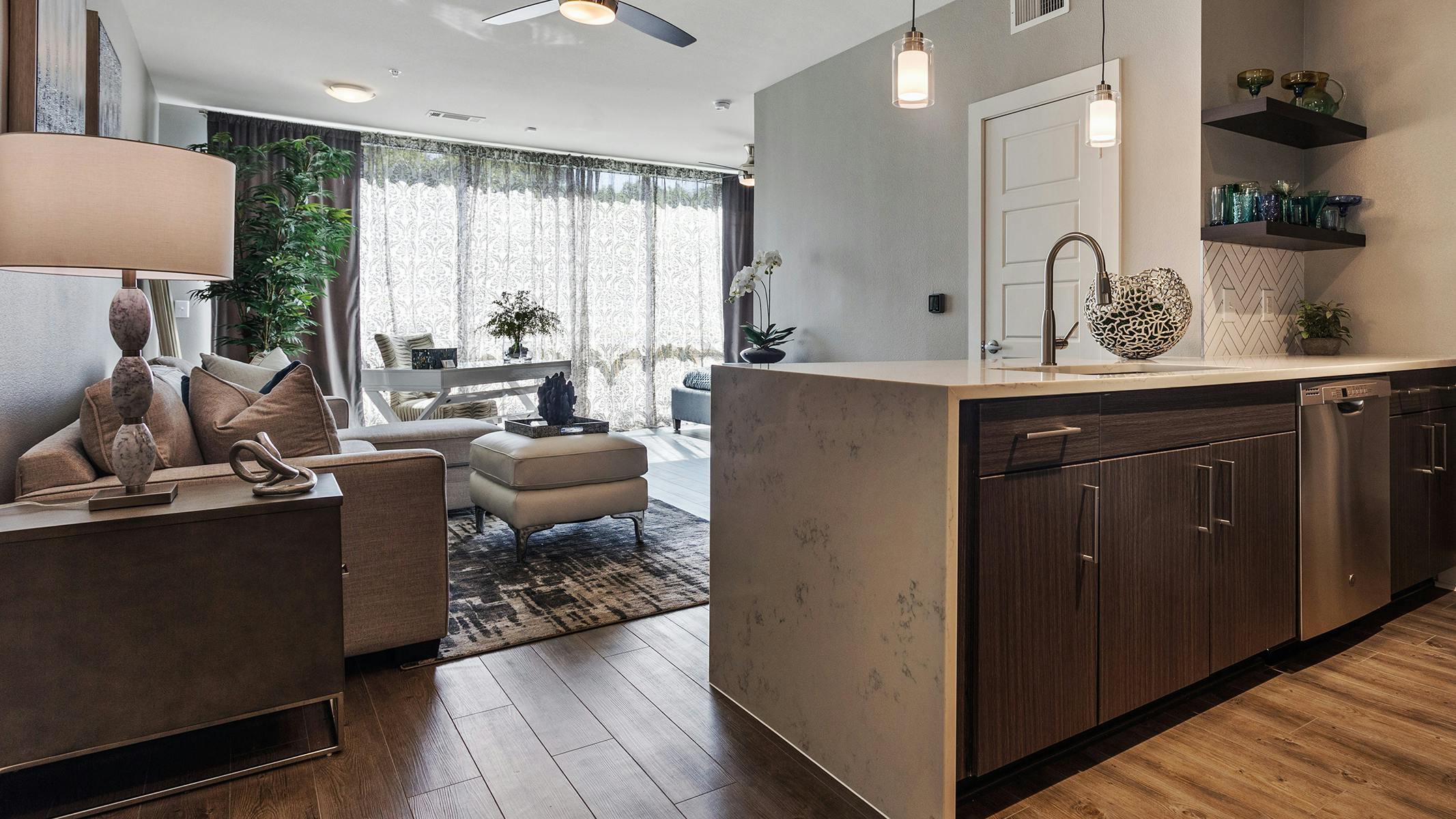 AMLI South Shore studio apartment with view of living room with wood floors from kitchen