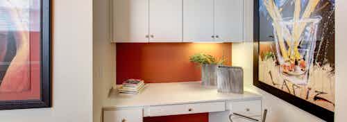 Interior view of built-in white desk with drawers and cabinets above with gold knobs at AMLI Memorial Heights apartments