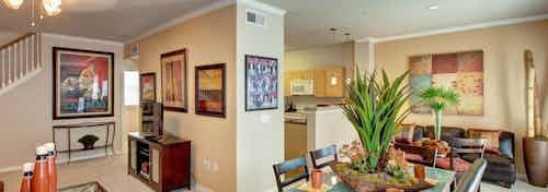 AMLI Memorial Heights apartment dining room with table and chairs and living room at left and kitchen in background