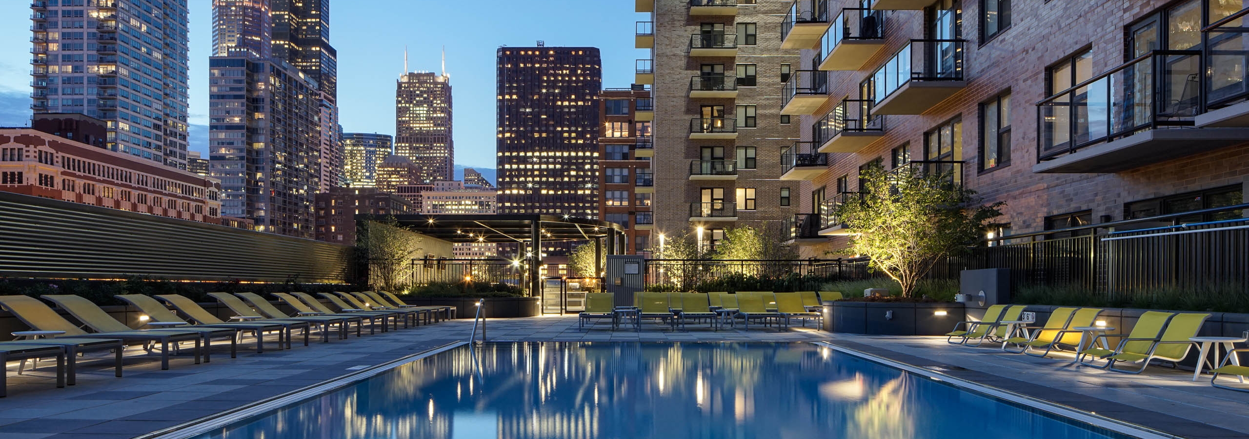 Night view of AMLI Lofts apartments pool with Chicago skyline in the distance
