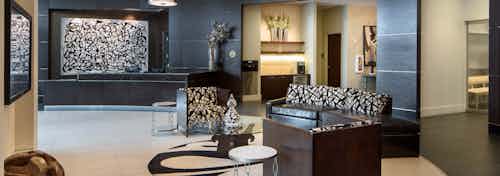 Lobby at AMLI Design District apartments with brown leather couch and black and white upholstered chairs and artwork