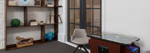 Arcade game with chairs near display shelves and doorway in clubroom at AMLI Memorial Heights apartments