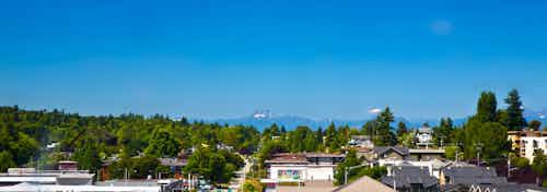 Sunny daytime exterior view from an apartment at AMLI Mark24 looking west with the snow capped Olympics on the horizon