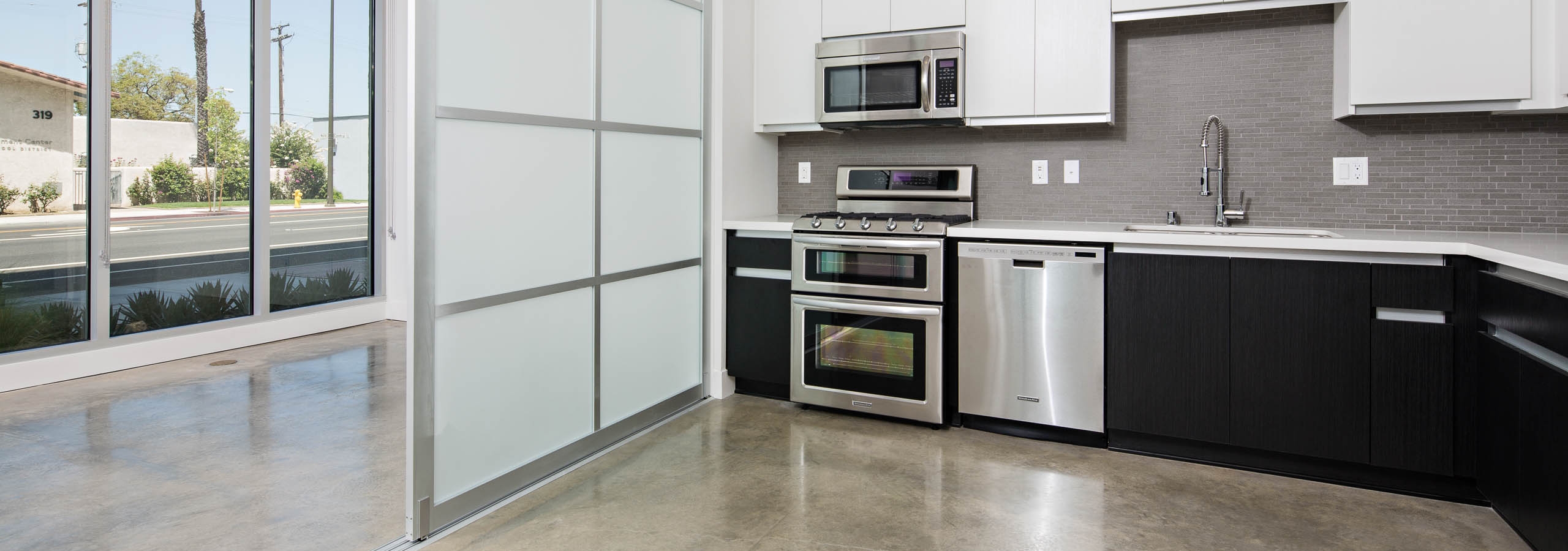 Lex on Orange kitchen with polished concrete floors and stainless steel appliances