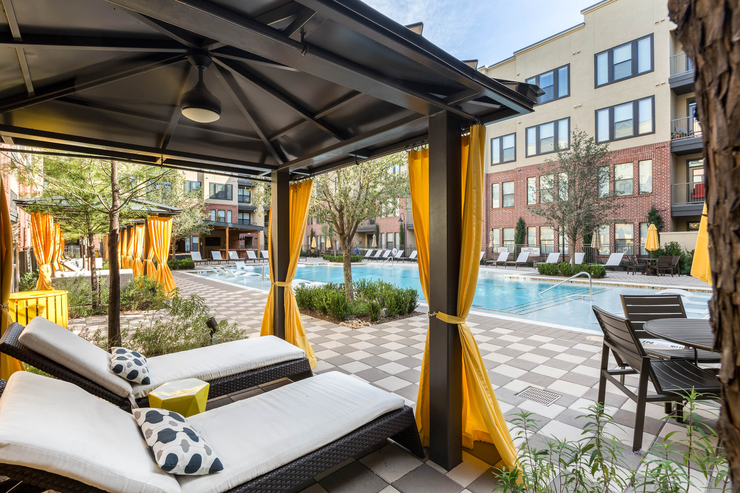 West Plano cabanas with yellow curtains and loungers
