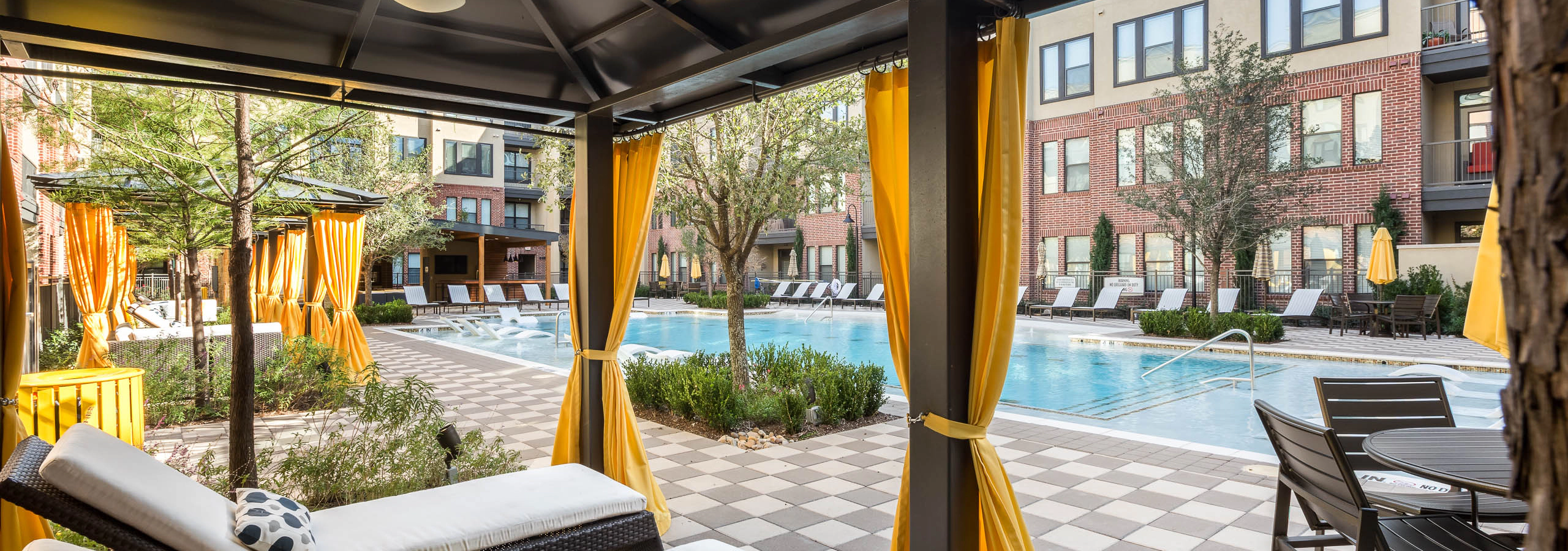 West Plano cabanas with yellow curtains and loungers