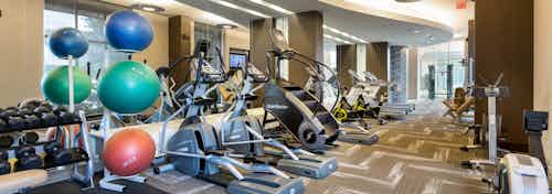 AMLI River Oaks fitness center with strength and cardio equipment’s and dumbbells and colorful stability balls at left