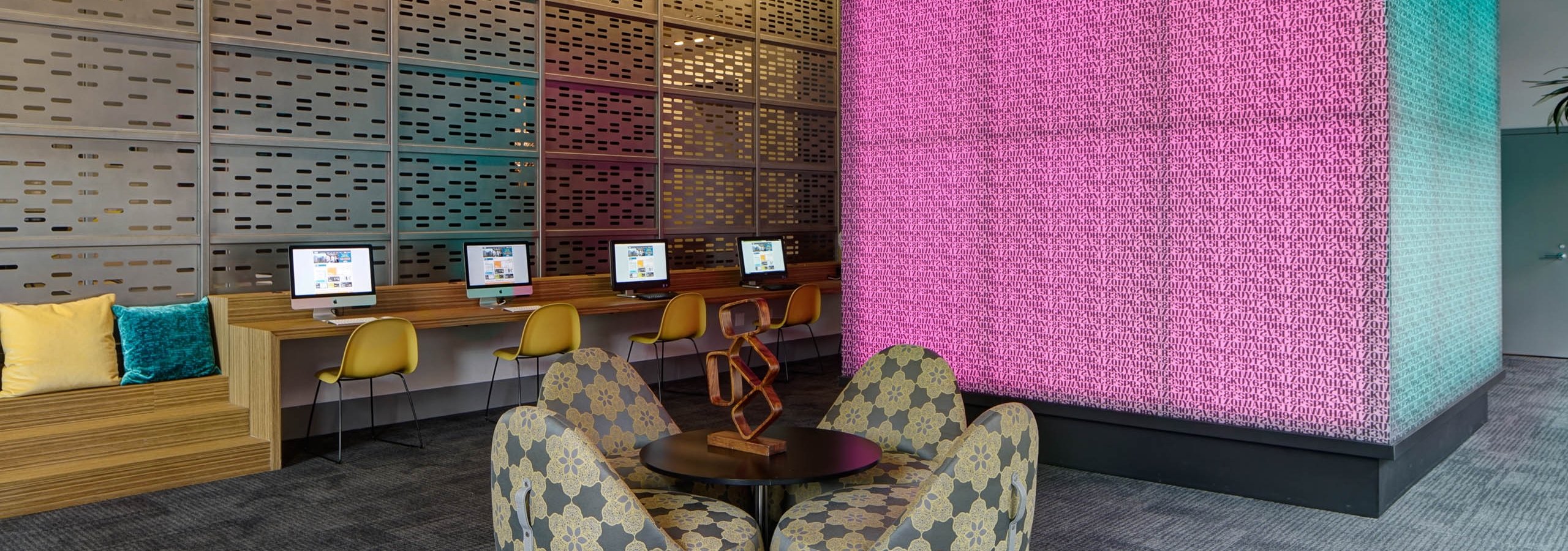 Interior view of the tech lounge at AMLI Lofts with a large pink cube that changes color serving as the focal point
