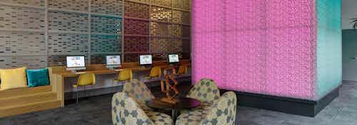 Interior view of the tech lounge at AMLI Lofts with a large pink cube that changes color serving as the focal point