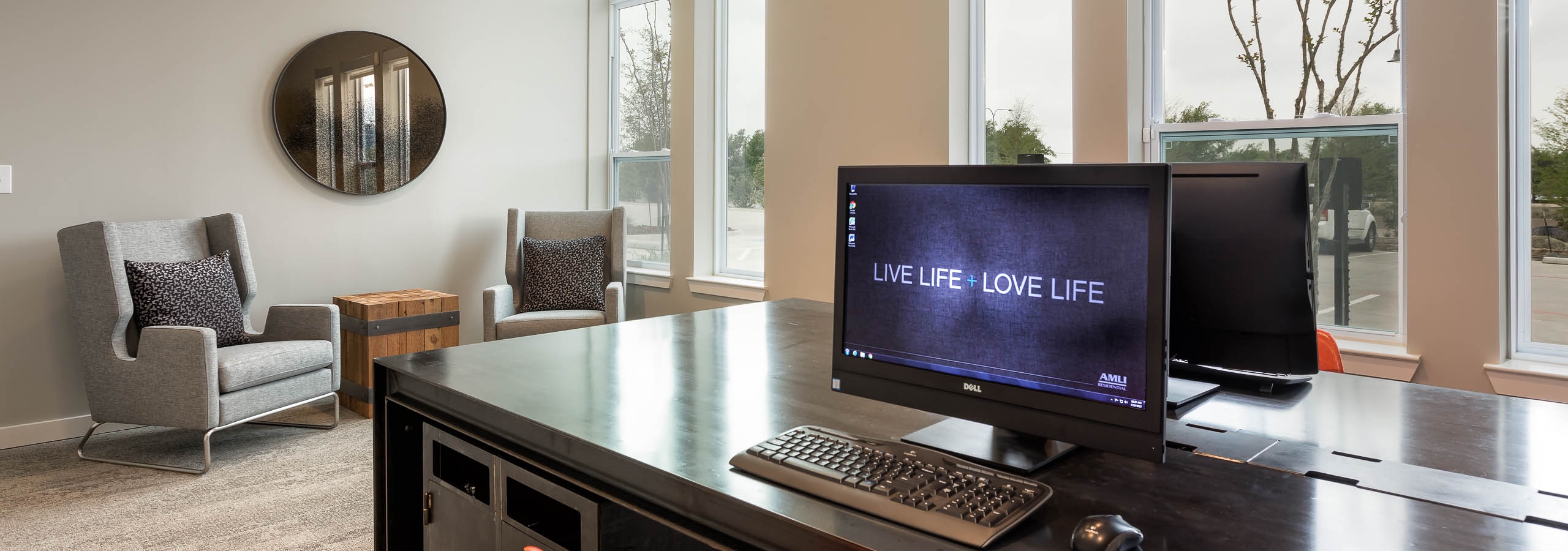 Interior view of business center at AMLI Frisco Crossing apartment building with computer stations and comfortable seating