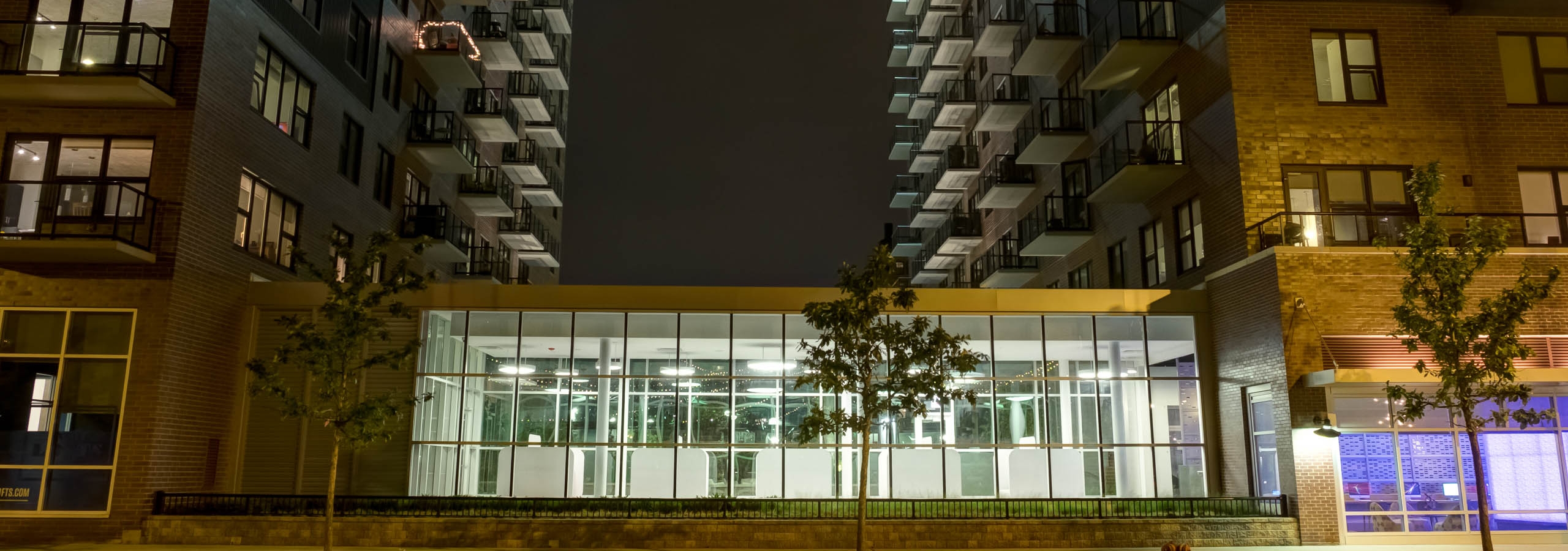 Exterior view of the AMLI Lofts apartment community building facade brightly lit up at night time in the city of Chicago