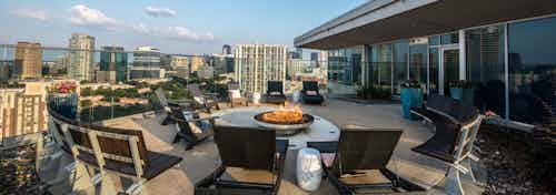 Daytime view of rooftop fire pit overlooking Dallas for penthouse residents at AMLI Design District apartment building