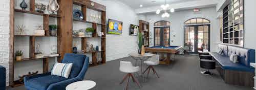 AMLI Memorial Heights clubroom with large brown display shelves, various seating, billiards table and arcade game