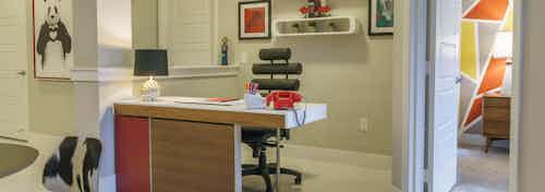 Interior view of a built-in office desk and work area at an AMLI Sawgrass Village apartment with creative shelving behind