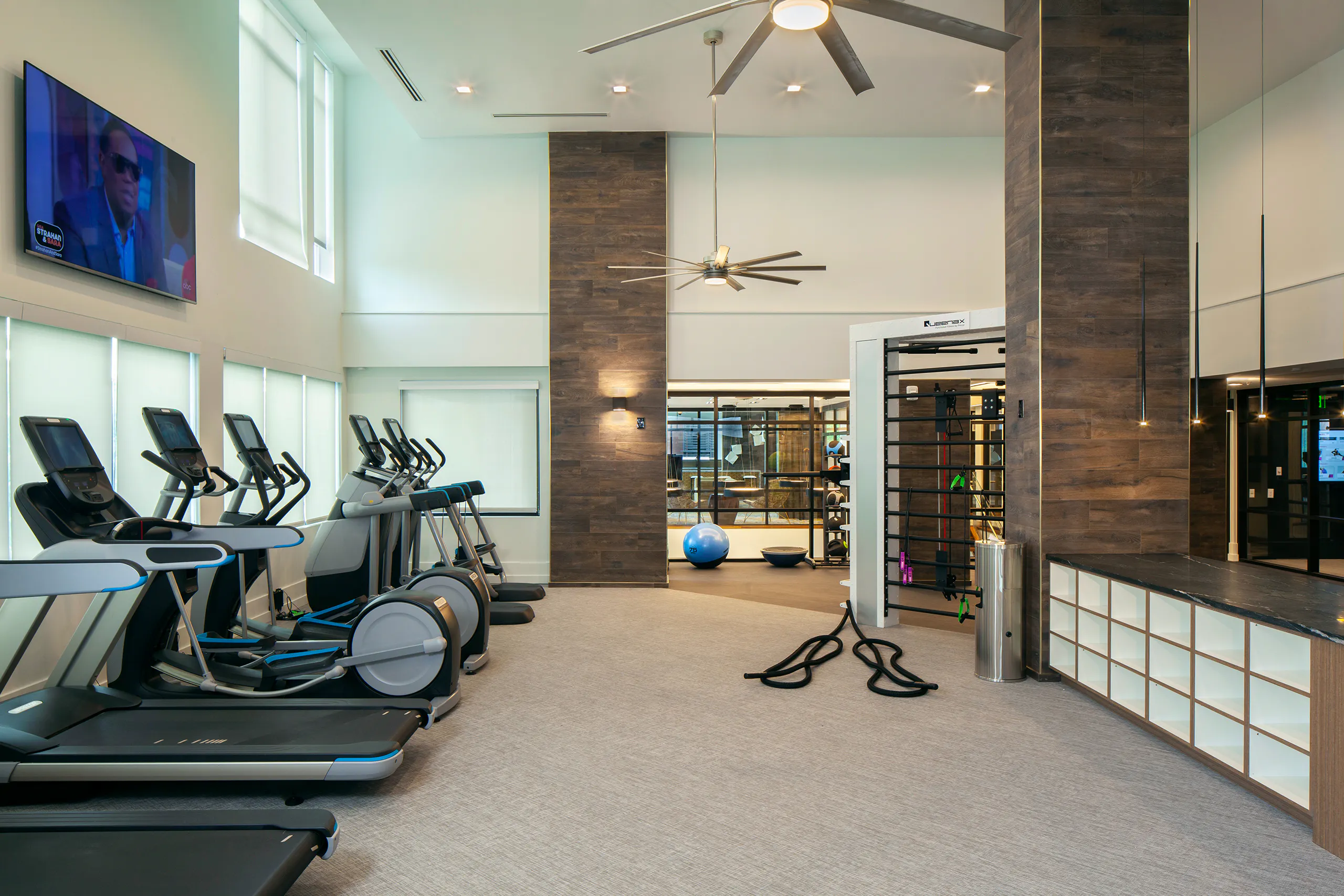 AMLI Riverfront Green apartments fitness center with treadmills and ellipticals set on beige carpet