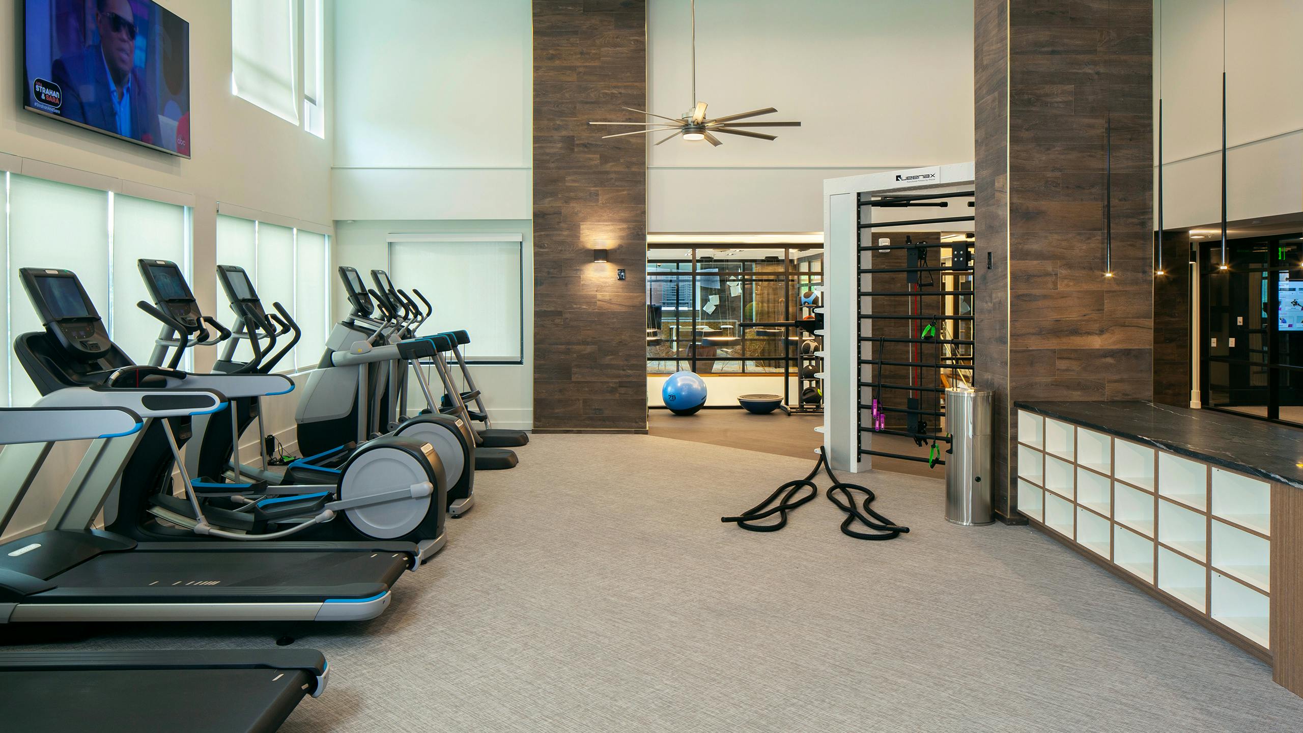AMLI Riverfront Green apartments fitness center with treadmills and ellipticals set on beige carpet